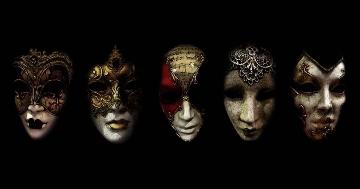 A row of ornate theater masks against a black background