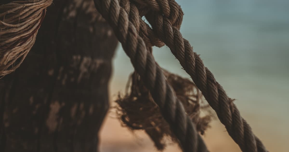 A weathered rope pulled taut around a wooden post