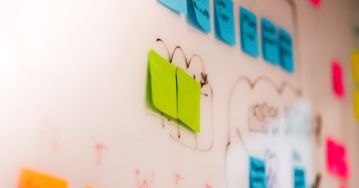 Colorful sticky notes and hand-drawn arrows on a whiteboard