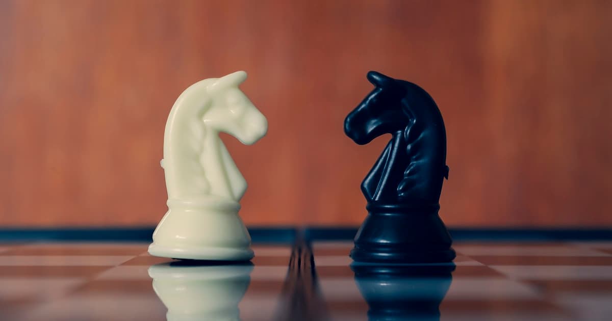 Two chess knights facing each other on a chessboard