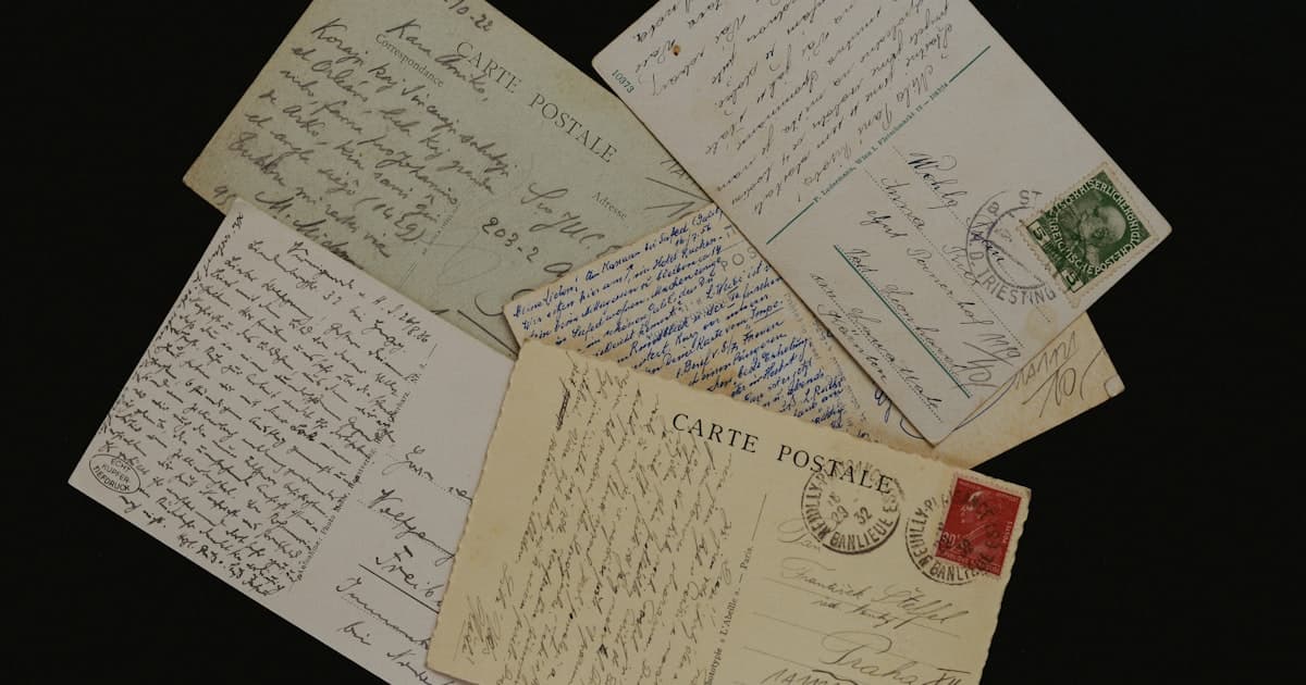 Vintage handwritten postcards and letters on a dark surface