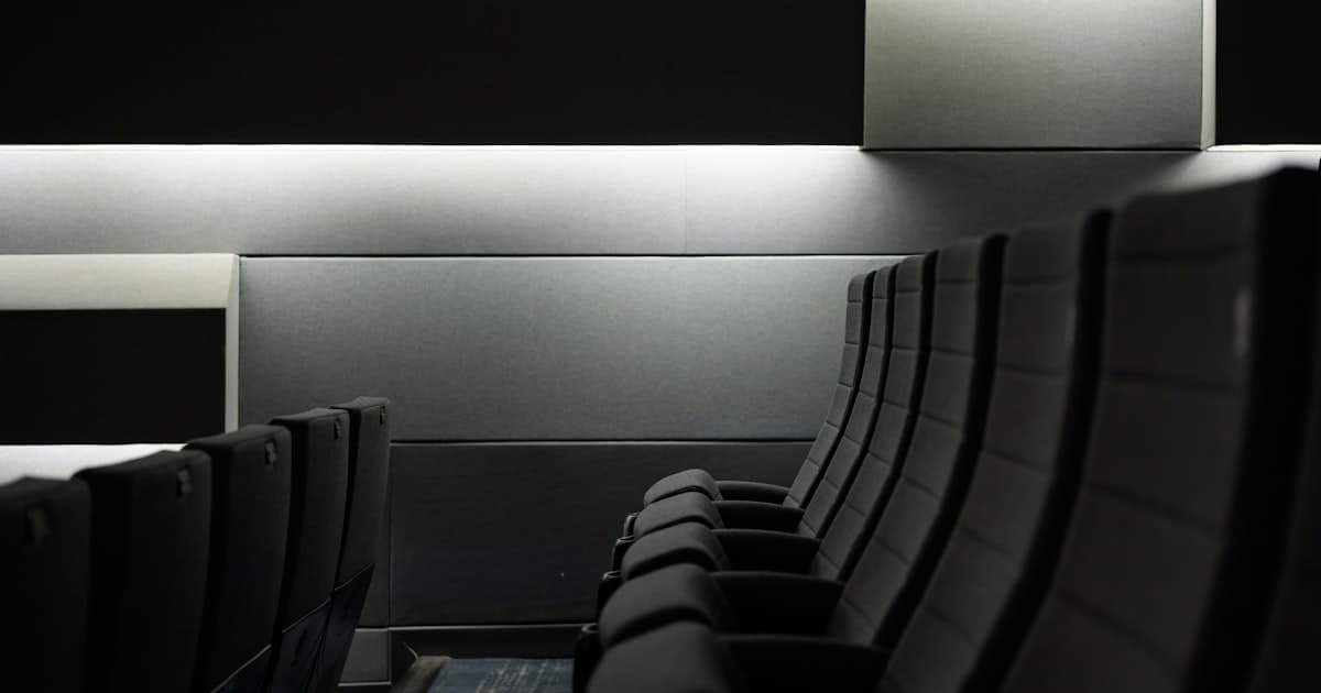 Rows of empty dark seats in a dimly lit lecture room