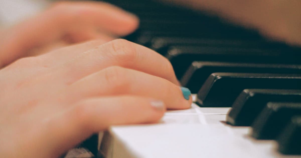 Hands practicing on piano keys in close-up